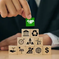 A person holds green wooden blocks with handshake icons standing with other ESG icons of sustainable development.