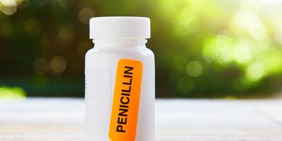 A bright orange sticker saying Penicillin stuck on a container of antibiotics.