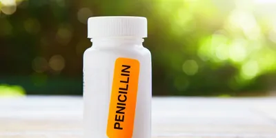 A bright orange sticker saying Penicillin stuck on a container of antibiotics.