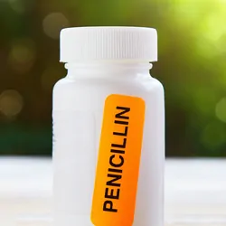 A bright orange sticker saying Penicillin stuck on a container of antibiotics.