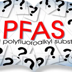 An opened book with PFAS written on it and surrounded with question marks.
