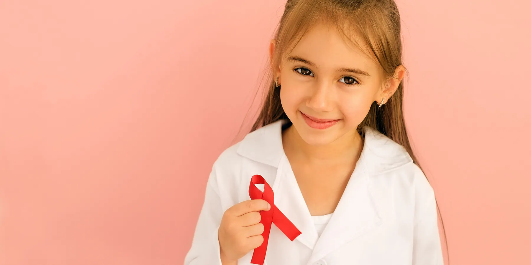 A smiling girl with a red ribbon loop in right hand as a symbol of HIV awareness