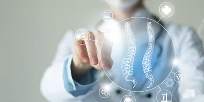 Clinician points to interactive, virtual vectors of the spinal cord and medicine-related icons.