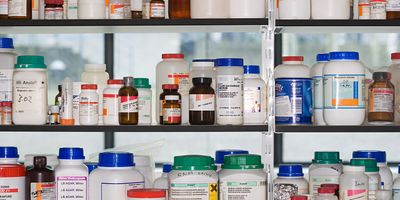 Bottles of chemicals arranged on a shelf in a lab.