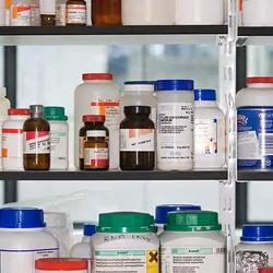 Bottles of chemicals arranged on a shelf in a lab.