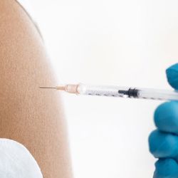 a medical professional giving someone a vaccine 