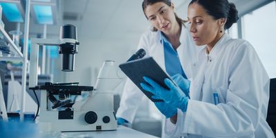 two scientists looking at a digital assistant program in the lab