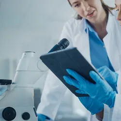 two scientists looking at a digital assistant program in the lab