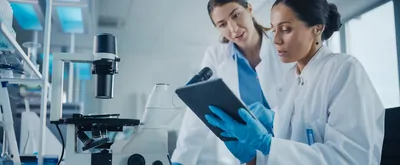 two scientists looking at a digital assistant program in the lab
