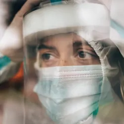 Photo of a medical laboratory technologist under pressure wearing personal protective equipment during the pandemic.