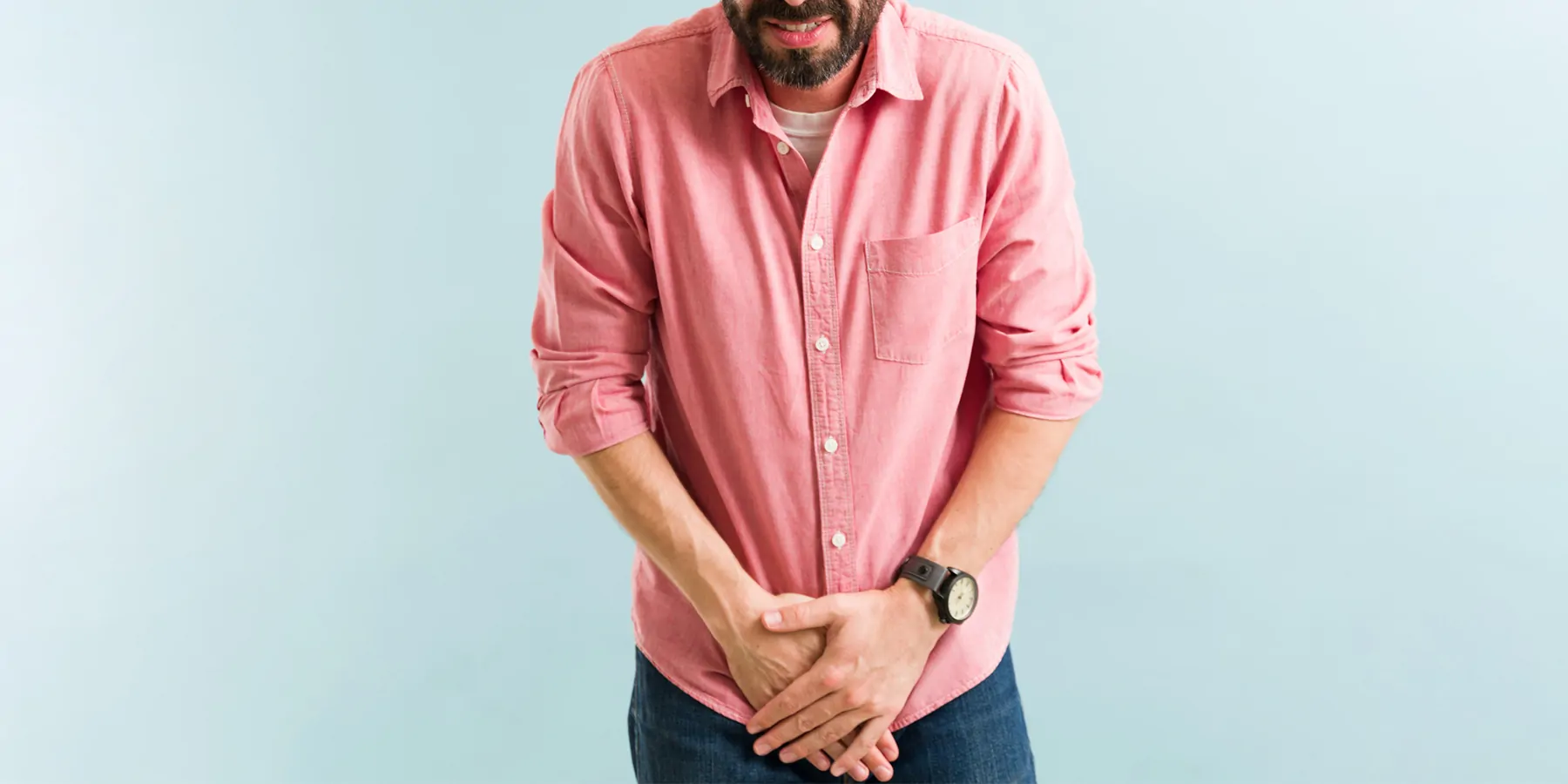 A man with a bladder infection winces in pain as he places his hands near his genitals.