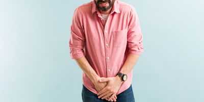 A man with a bladder infection winces in pain as he places his hands near his genitals.