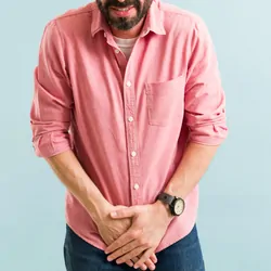 A man with a bladder infection winces in pain as he places his hands near his genitals.
