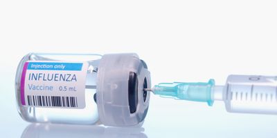 An influenza vaccine vial with a syringe ready to be loaded.