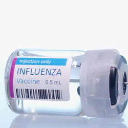 An influenza vaccine vial with a syringe ready to be loaded.
