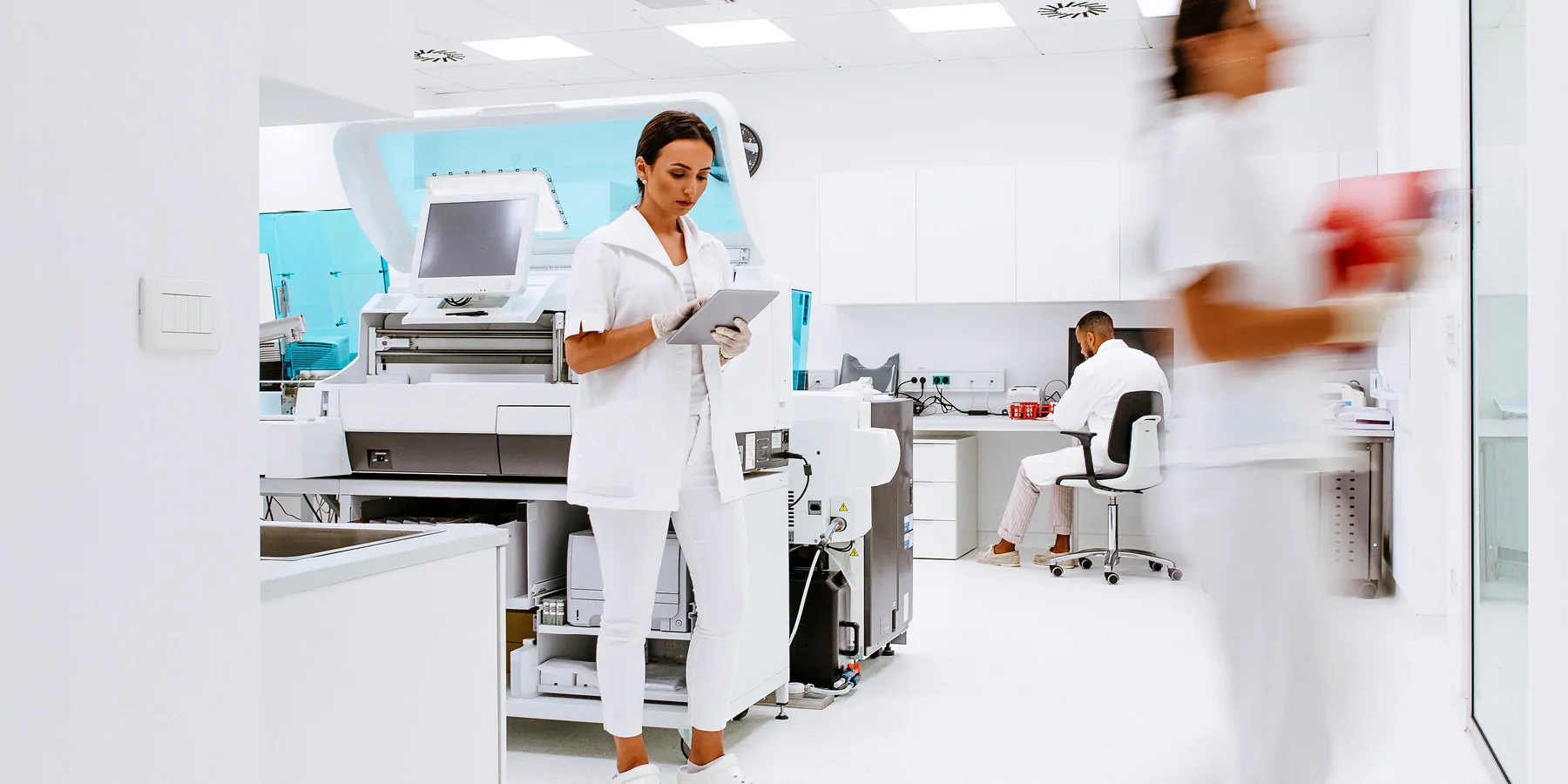 Workflow Automation Can Address the Needs of Large and Small Labs Scientists working in the laboratory surrounded by large equipment.