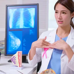 A close up of a Woman Holding a Heart with Ribbon on her Breast
