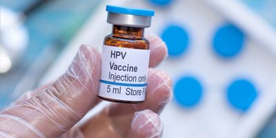 A clinician holds a vial of human papillomavirus or HPV vaccine.