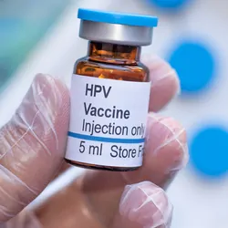 A clinician holds a vial of human papillomavirus or HPV vaccine.
