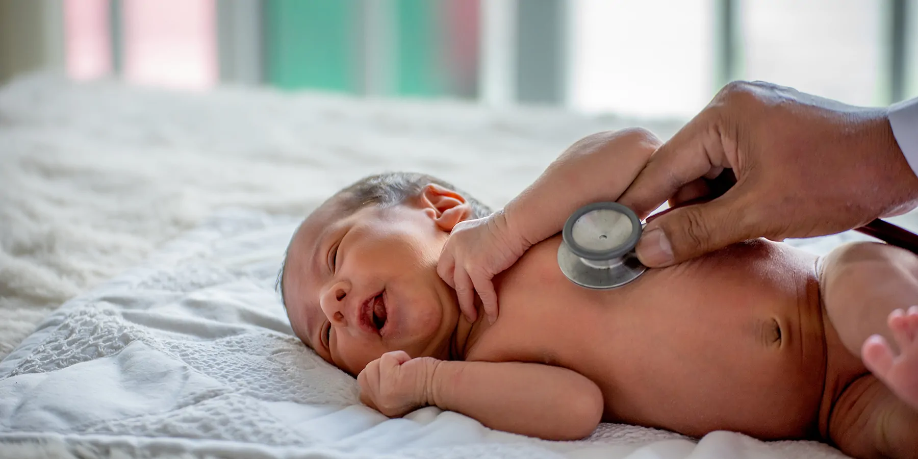 US Newborn Syphilis Cases See 10x Spike Over a Decade A clinician checks a newborn baby with a stethoscope in a hospital.