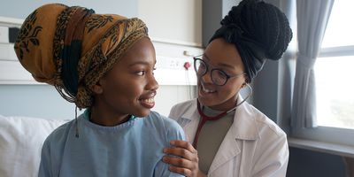 A female clinician checks a young girl's heartbeat with a stethoscope in a hospital ward.