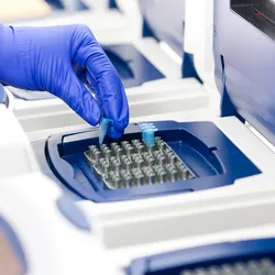 Technician performing syndromic PCR testing in laboratory