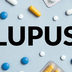 The word Lupus is surrounded by pills and medical supplies on a blue background.