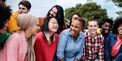 A multiethnic diverse group of people having fun outdoors and smiling at the camera.