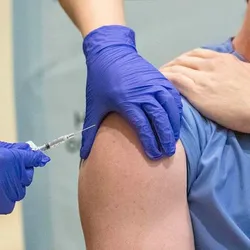 Photo of a person receiving an RNA-based vaccine injected in their upper arm.