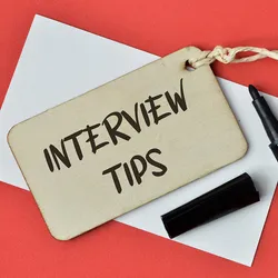 Photo of a wooden tag that reads “interview tips” on a red background.