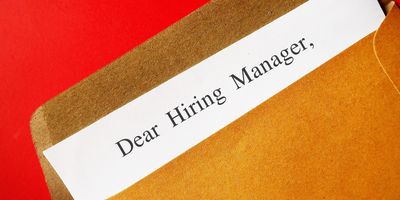 Photo of a letter-sized envelope with the text “Dear Hiring Manager” written on the top of a piece of paper sticking out of the envelope.