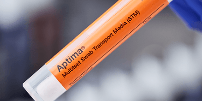 Orange vial with "Aptima Multitest Swab Transport Media (STM)" written in black lettering with grey background.
