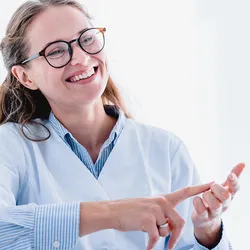Photo of a White female medical laboratory manager smiling while conducting a hiring interview with a potential lab candidate.