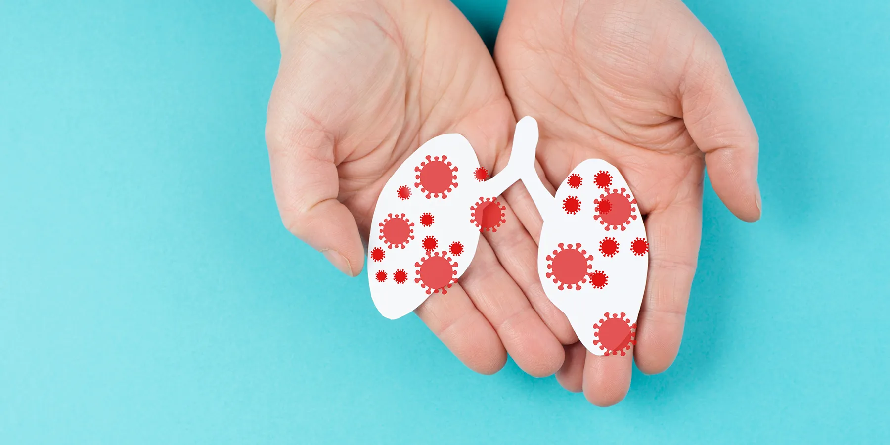 Illustration of a pair of human hands holding a paper cutout of lungs with infections.
