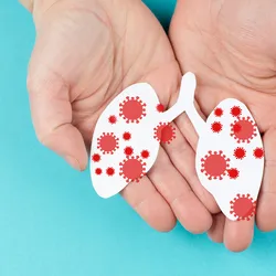Illustration of a pair of human hands holding a paper cutout of lungs with infections.