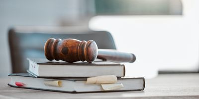Photo of a gavel resting atop of a pile of law books in a US lawmaker’s office.