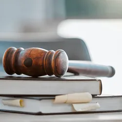 Photo of a gavel resting atop of a pile of law books in a US lawmaker’s office.