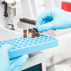Photo of a clinical researcher wearing blue gloves loading samples for circulating microRNA analysis.