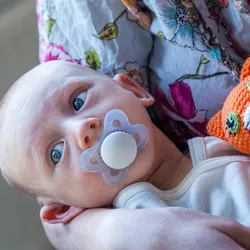 Photo of a mother who is holding her newborn baby in her arms.