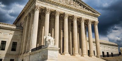 Photo taken of the front of the U.S. Supreme Court showing stairs and large columns.