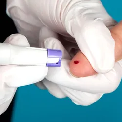 Photo of a healthcare worker pricking the finger of a patient to take a small blood sample.