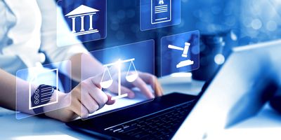 Photo of a clinical lab professional typing at a laptop keyboard with legal symbols overlayed on top of the photo.