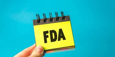 Photo of someone holding a yellow sticky note in their hand that reads FDA – U.S. Food and Drug Administration.