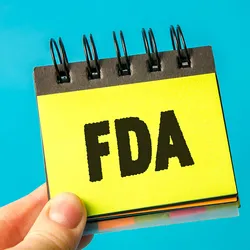 Photo of someone holding a yellow sticky note in their hand that reads FDA – U.S. Food and Drug Administration.