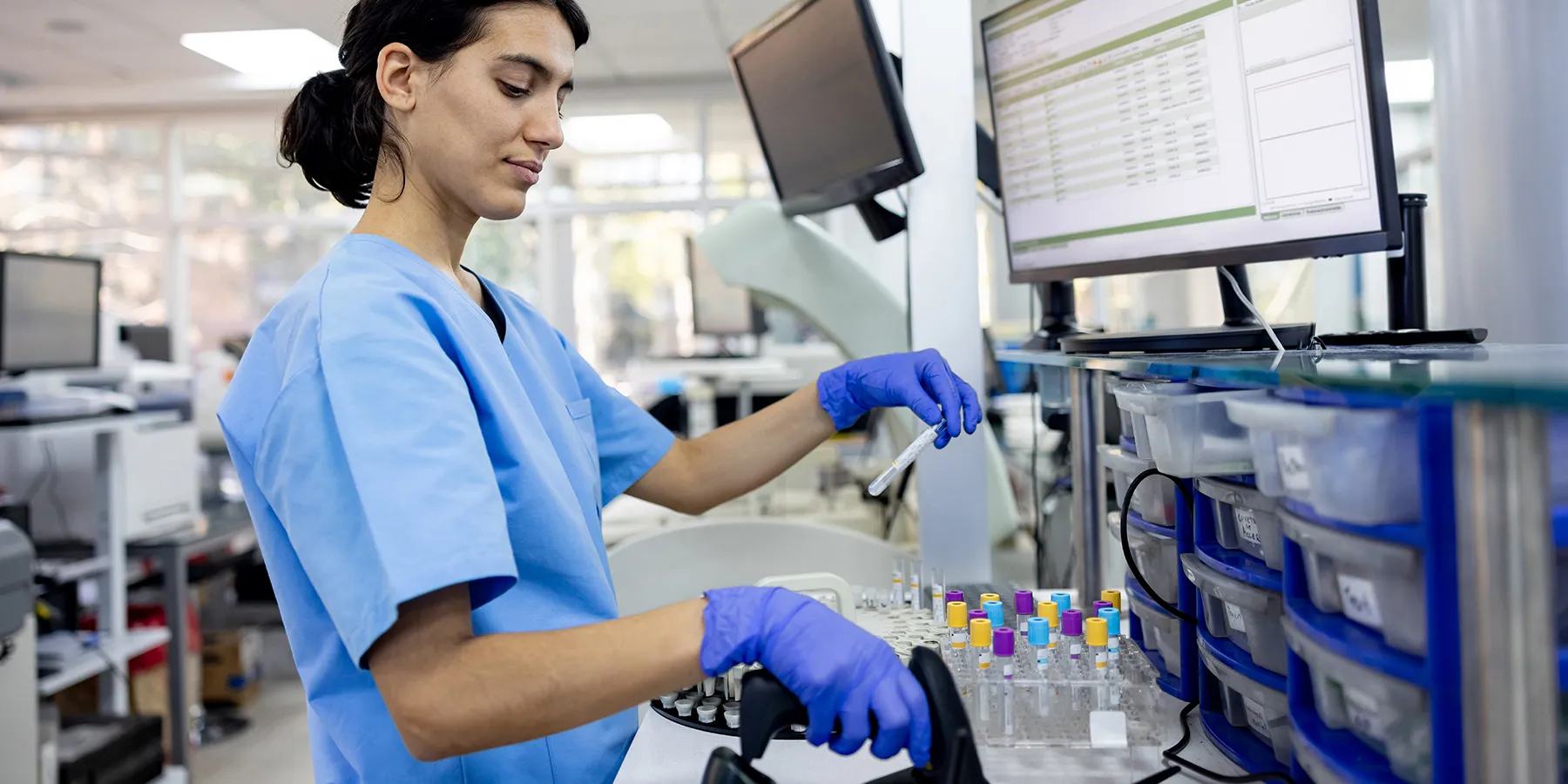 Photo of a hematologist wearing PPE in a clinical laboratory analyzing Alzheimer’s blood test samples.