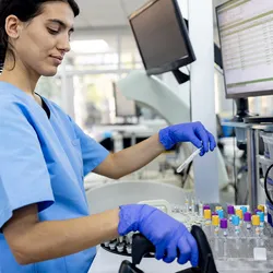 Photo of a hematologist wearing PPE in a clinical laboratory analyzing Alzheimer’s blood test samples.