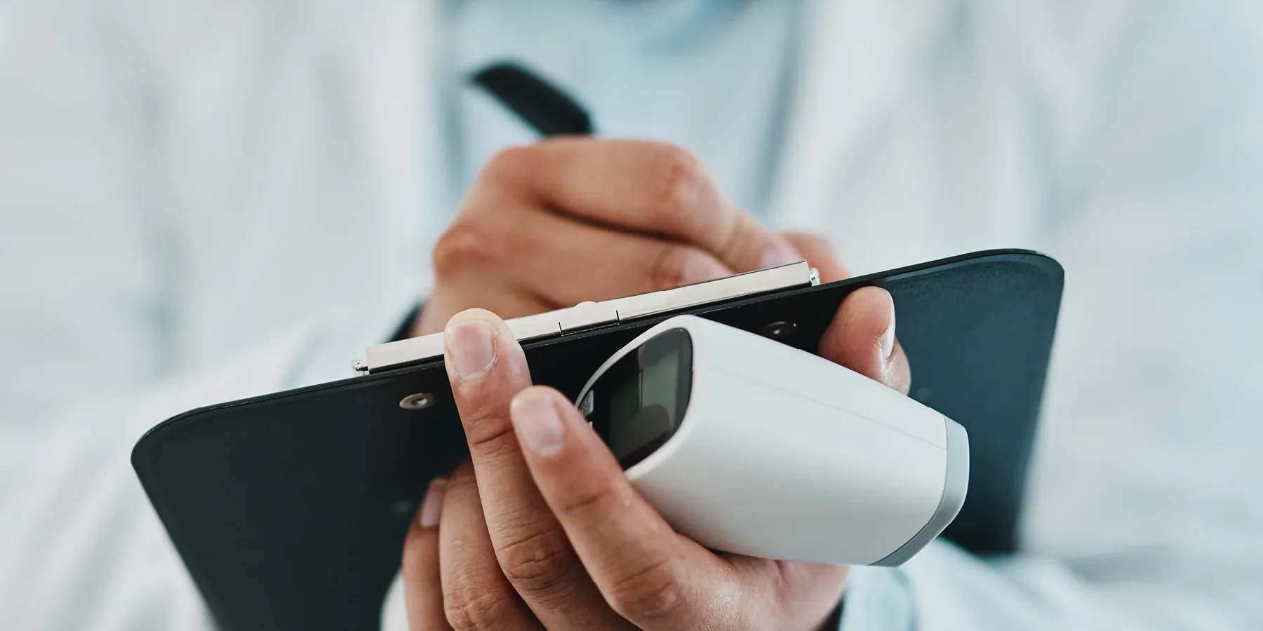 Photo of a clinical researcher wearing PPE holding a clipboard and a pen to fill out a research study form guidelines.