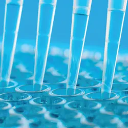 Photo of pipette tips in the clinical laboratory with a blue background.