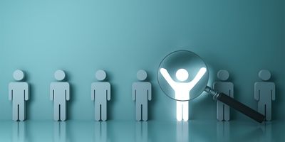 Illustration of several people standing in a line with a magnifying glass hovering over one of them.