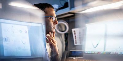 Photo of Yadav Sapkota, PhD, examining protein model data related to biomarkers that can predict cardiac issues in cancer survivors.